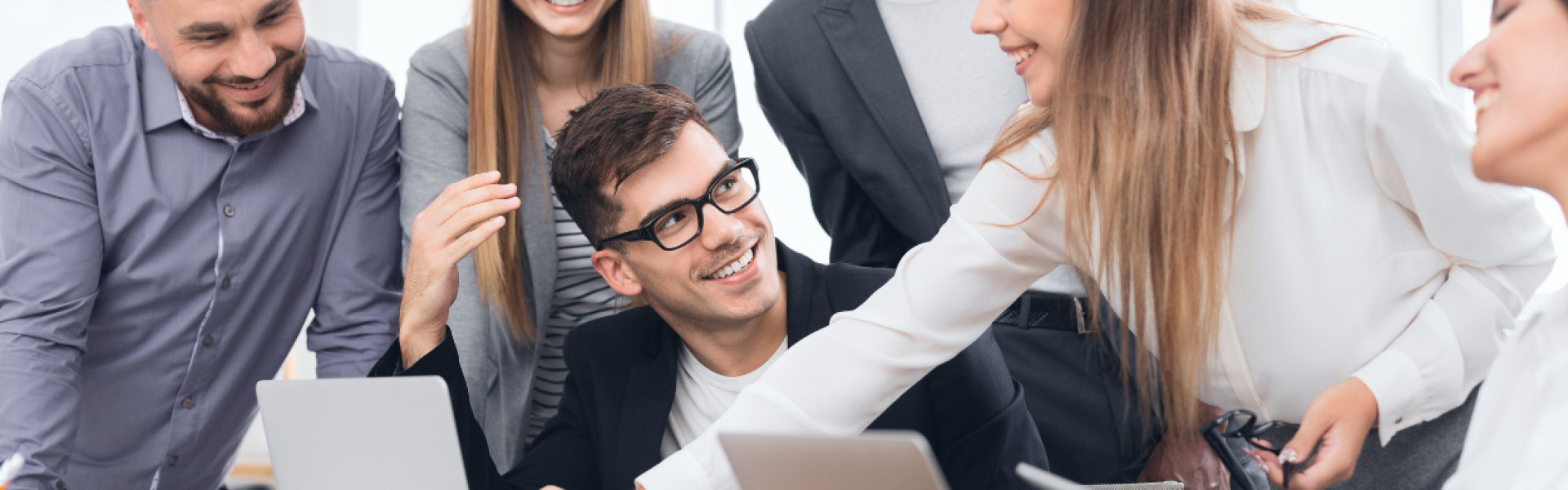 Recruitment team reviewing career site candidate applications together on a laptop in a modern office